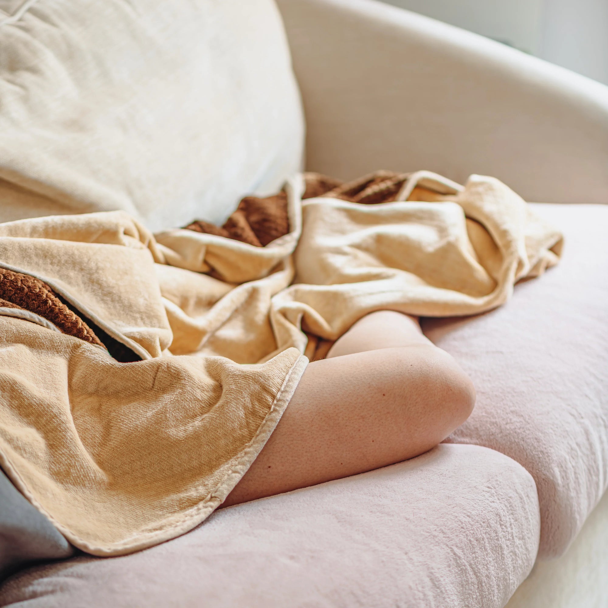 Plaid beige doux et imperméable sur canapé, idéal pour se détendre en toute sérénité